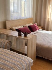 a bedroom with two beds and a table with two mugs on it at Malūno namai 2 in Palanga