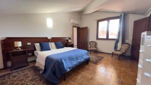 a bedroom with a bed and two chairs and a window at B&B La Pitagora in Porto Garibaldi