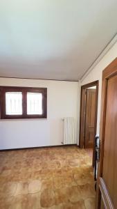 an empty room with two windows and a door at B&B La Pitagora in Porto Garibaldi