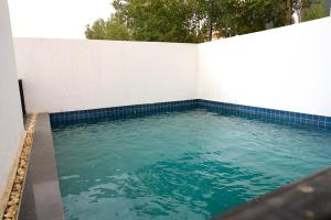 a pool of water with a white wall at Alammariah Hills Resort- Riyadh in Diriyah