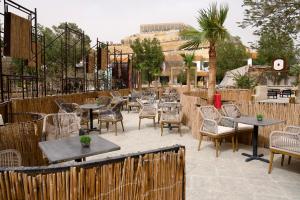 a patio with tables and chairs and a fence at Alammariah Hills Resort- Riyadh in Diriyah