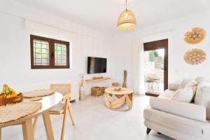 a white living room with a table and a couch at Lambda Luxury Villa 1 in Syvota
