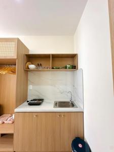 a small kitchen with a sink and wooden cabinets at Gold Lucky Homestay in Thôn Trường Giang