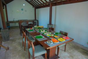 a long wooden table with plates of food on it at Villa Oceana By Heritage in Hikkaduwa