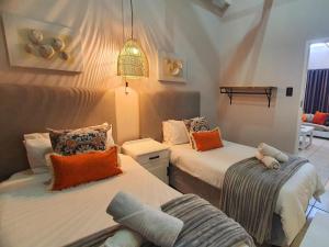 a bedroom with two beds and a couch at Point Village Hotel and Self Catering in Mossel Bay