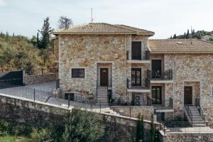 a stone house with a fence in front of it at Lambda Luxury Villa 1 in Syvota