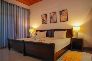 a bedroom with a large bed with two lamps at Villa Oceana By Heritage in Hikkaduwa
