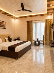 a bedroom with a bed with a ceiling fan at Paavan Palace in Ayodhya