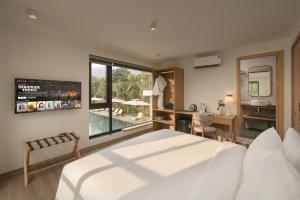 a bedroom with a bed and a bathroom with a sink at Rivana Retreat in Sóc Sơn