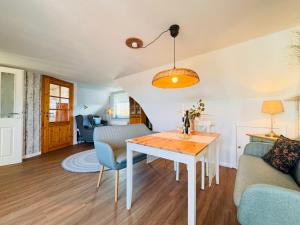 a living room with a table and a couch at Nordkiek No 8 Für 4 Person mit Meerblick in Westerholz +23 photos