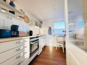 a kitchen with white cabinets and a counter top at Nordkiek No 8 Für 4 Person mit Meerblick in Westerholz