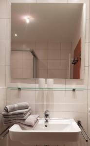 a bathroom with a sink and a mirror and towels at Alte Teestube Alte Teestube 14 in Norderney +6 photos