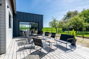 a group of chairs and tables on a deck at L'Evasion, Piscine et jacuzzi in Lescherolles