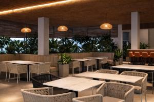 a restaurant with tables and chairs and lights at Chethan International in Bangalore