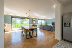 a dining room and living room with a table and chairs at L'Evasion, Piscine et jacuzzi in Lescherolles