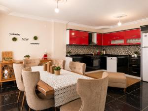 a kitchen with a table and chairs and red cabinets at Begonville Villas Ladies Beach in Kuşadası +16 photos