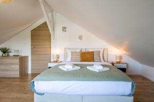 a bedroom with a bed with two towels on it at L'Evasion, Piscine et jacuzzi in Lescherolles +60 photos