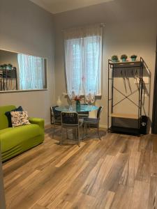 a living room with a green couch and a table at Fiori 3 Apartment in Milan