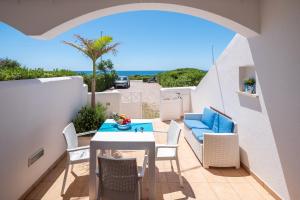 a patio with a table and chairs and the ocean at Residence Salento Fronte Mare - Coste del Sud it in Torre San Giovanni Ugento
