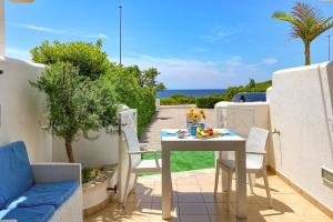 a table and chairs on a patio with a view of the ocean at Residence Salento Fronte Mare - Coste del Sud it in Torre San Giovanni Ugento