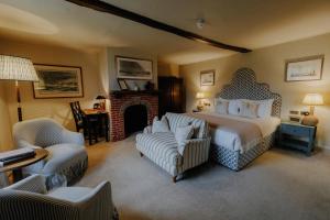 a bedroom with a bed and chairs and a fireplace at Master Builder's House Hotel in Beaulieu +41 photos