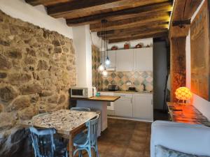 a kitchen with a table and a stone wall at Casa Fabiana in Montenegro de Cameros