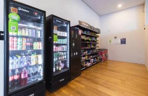 two large refrigerators in a store with drinks at Studio Centro Curitiba - para ate 3 pessoad in Curitiba