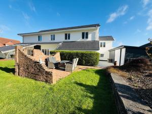 a house with a brick staircase in front of a yard at Die Schlafstube - Boutiquehotel in Neuharlingersiel