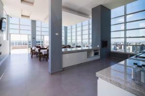 a large kitchen and dining room with tables and windows at Studio Centro Curitiba - para ate 3 pessoad in Curitiba