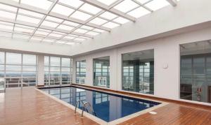 an indoor pool in a building with windows at Studio Centro Curitiba - para ate 3 pessoad in Curitiba