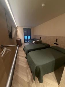 a hotel room with two beds and a television at Bearan Rooms 2 in Pamplona +17 photos