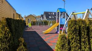 a playground with a slide in a yard at Yellow House Dziwnów in Dziwnów