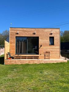 a small house with a large window in a yard at Sof tiny in Moyenmoutier +2 photos