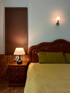 a bedroom with a bed and a lamp on a night stand at Spacious 1br White House in Ban Nok