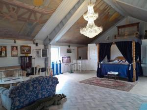 a living room with a bed and a chandelier at Borgahallen The Wedding Room in Rimbo
