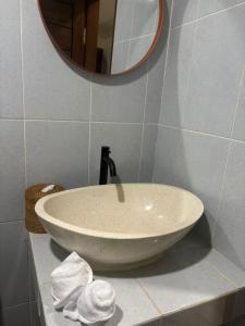 a sink in a bathroom with a mirror and towels at Tiny House Nusa Lembongan in Nusa Lembongan