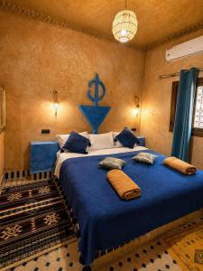 a bedroom with a blue bed with an anchor on the wall at Camels House in Merzouga
