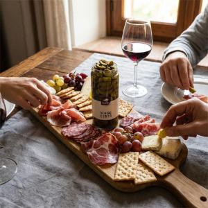 a table with a plate of food and a glass of wine at Agriturismo Salella in Salento