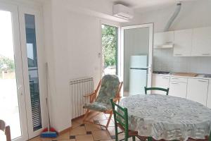 a kitchen with a table and a chair and a table and a kitchen with at Appartamento Nettuno in Villa Daria a 2 Km dal mare golfo del Tigullio in Chiavari