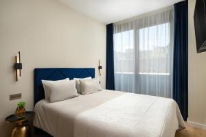 a bedroom with a large bed and a window at Emerald Downtown Luxury Suites by Continental Group in Budapest
