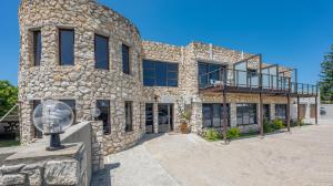 a stone building with a balcony on top of it at Stonehouse on Main in Struisbaai