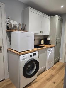 a kitchen with a washing machine and a washer at Casa Rosa Cheltenham - luxury unit, free parking - 5 star in Cheltenham
