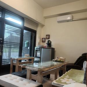 a living room with a table and a refrigerator at Kiutaro 2 in Yuli