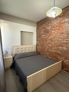 a bedroom with a brick wall and a bed at The Bs Stay in Tirana +8 photos