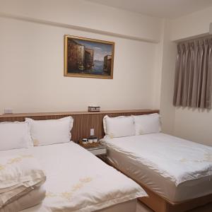 a room with two beds and a picture on the wall at Kiutaro 2 in Yuli