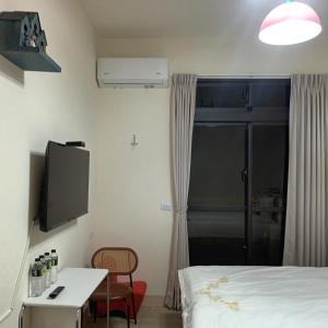 a bedroom with a bed and a tv and a table at Kiutaro 2 in Yuli