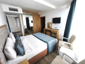 a bedroom with a bed and a desk and a television at BEACHFRONT SUNPORT BOUTIQUE Hotel & Restaurant in Kyrenia