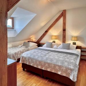 two beds in a room with a attic at Apartmány Bašta & Wellness in Sušice
