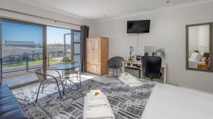 a living room with a bed and a table and chairs at Stonehouse on Main in Struisbaai