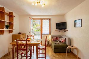 a living room with a table and a couch at Montagne E Coccole - Happy Rentals in Pré-Saint-Didier